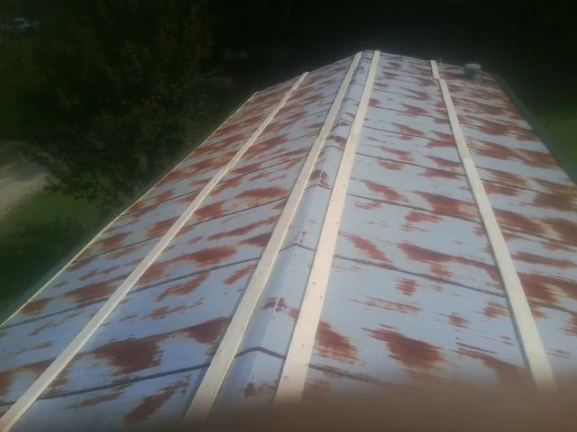 Rusted metal roof panels with new wood purlins before replacement — Storm Damage Roof Repair in Sleepy Eye by Roofing Brothers