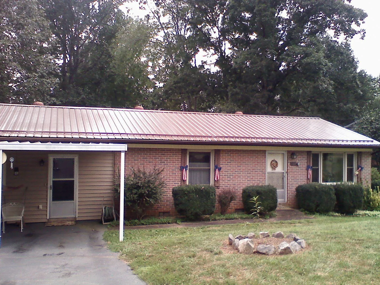 Bronze metal roof and carport on a brick ranch home — Roof Repair work by our crew in Sleepy Eye